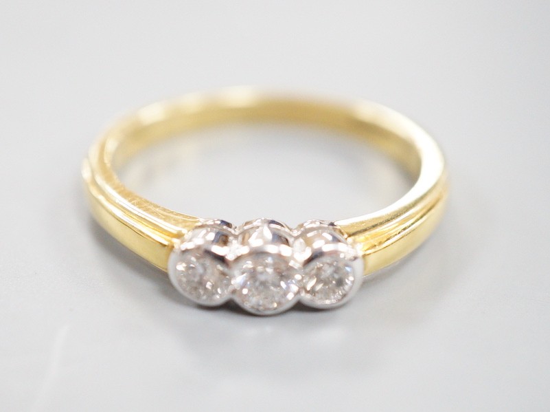 A modern 18ct gold and collet set three stone diamond ring, size P, gross weight 3.6 grams